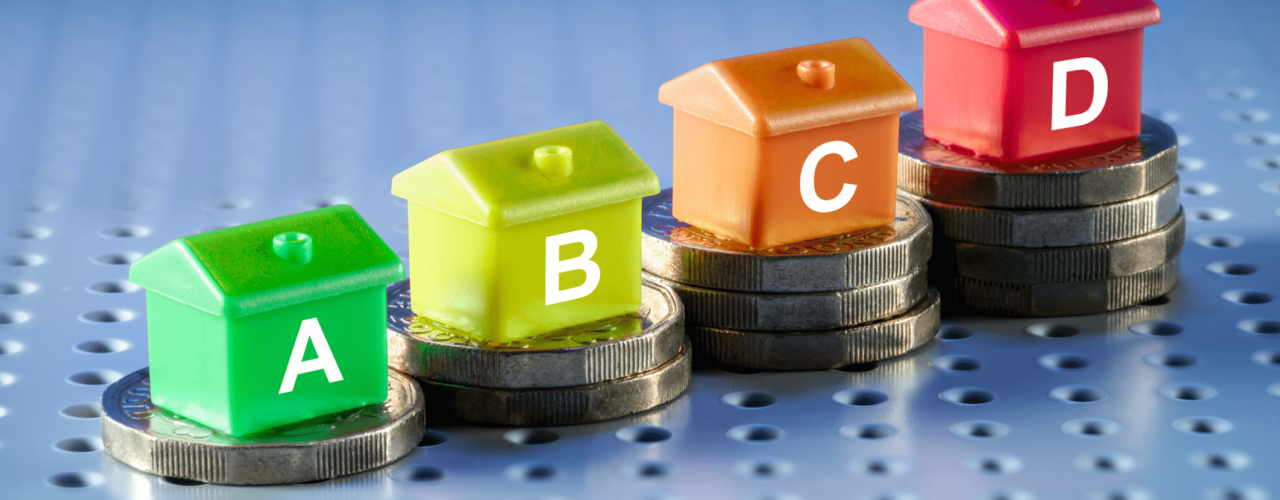 Model houses with the letters 'A', 'B', 'C' & 'D' sat on piles of pound coins.