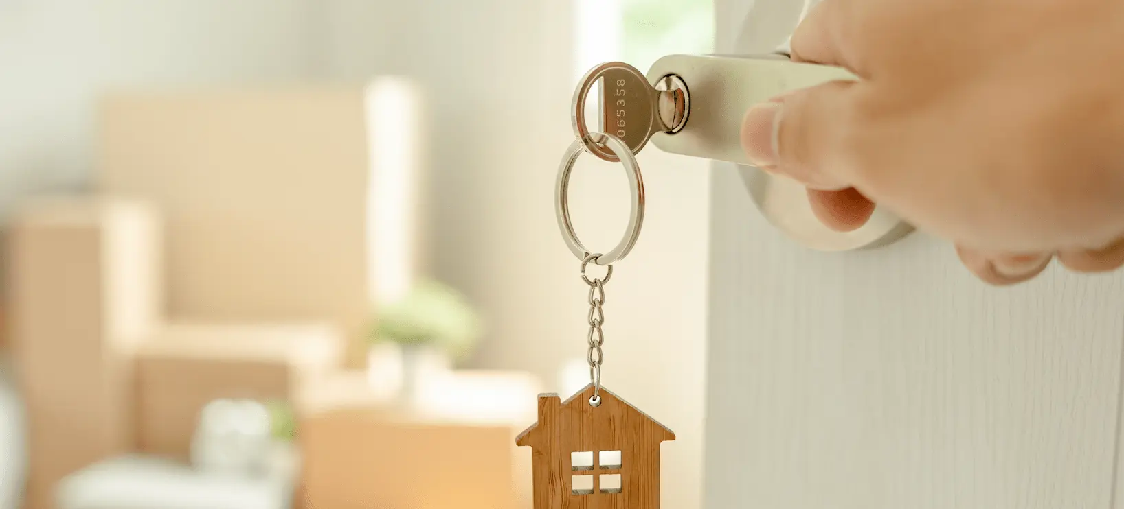 A key in the door with a model house as a keyring.