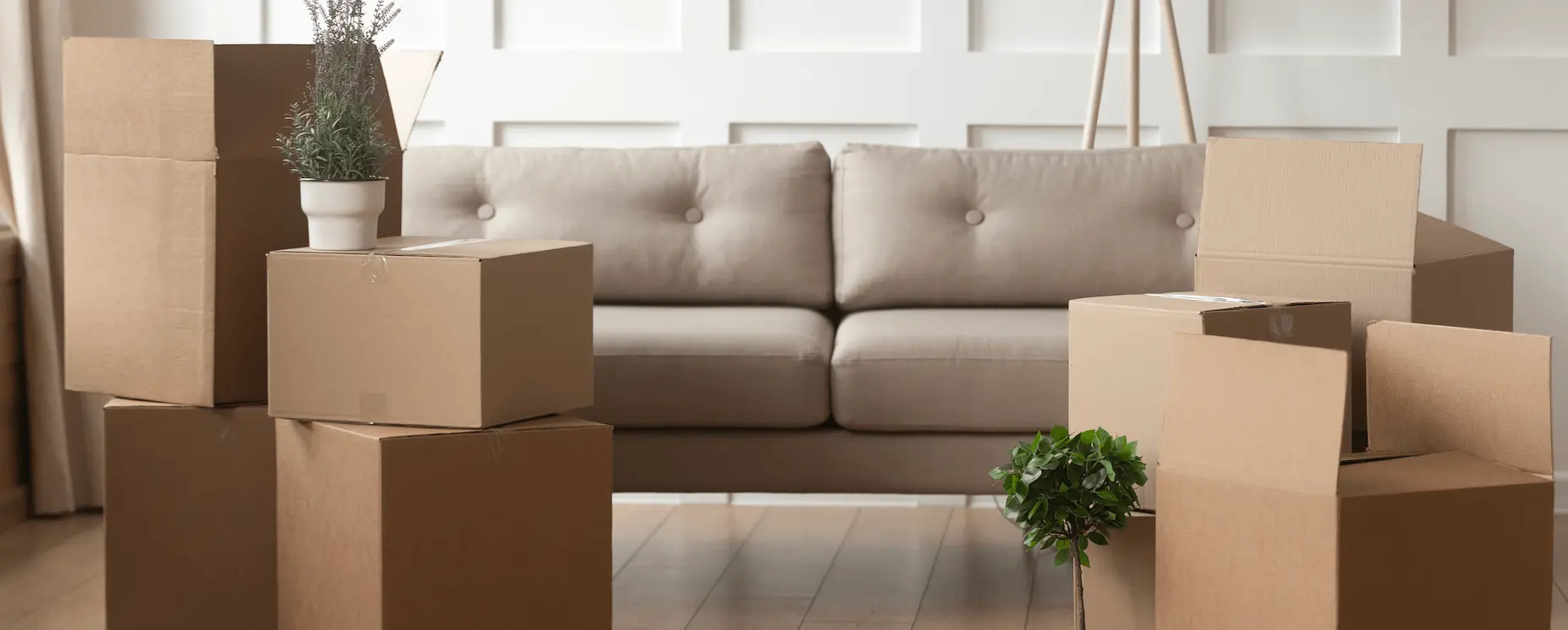 Cardboard boxes ready for moving, next to a sofa