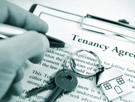 A tenancy agreement document with someone holding a pen