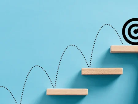 A dotted line bouncing upwards on wooden blocks to reach a target