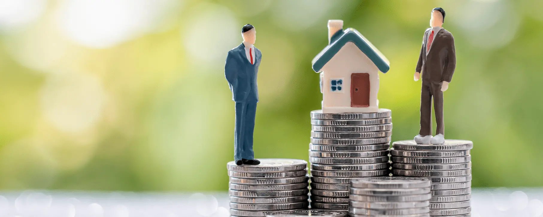 Two model people standing next to a model house with coins