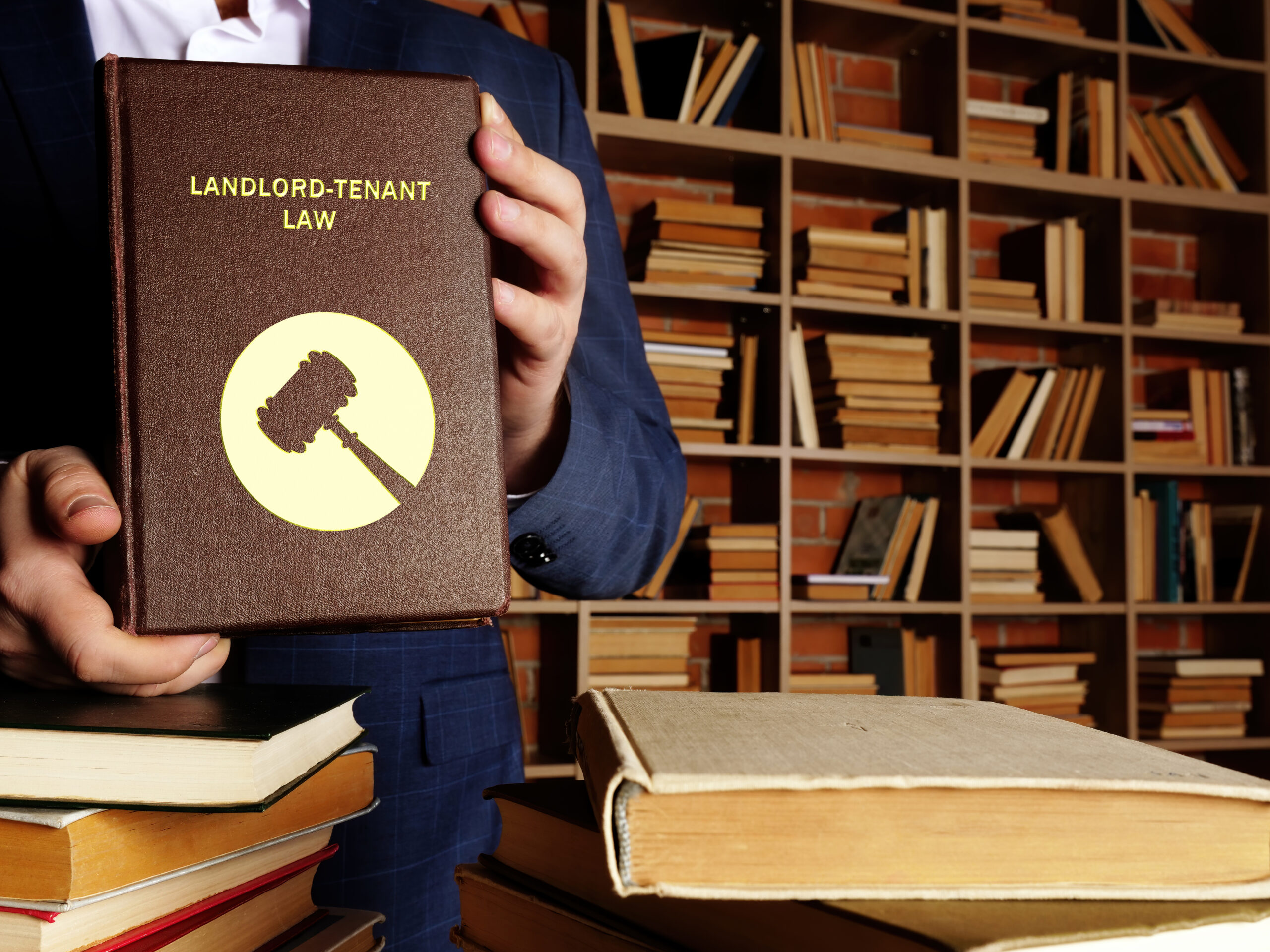 An image of a person holding a law book that says 'Landlord tenant law'