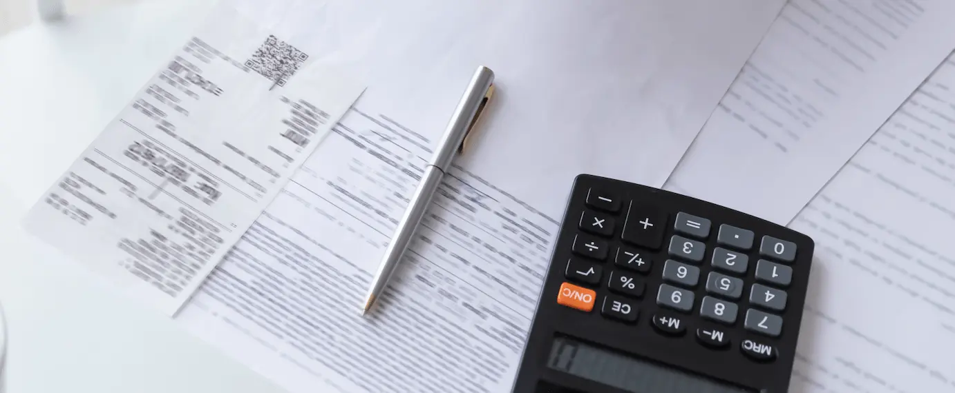 A paper bill with a pen and a calculator