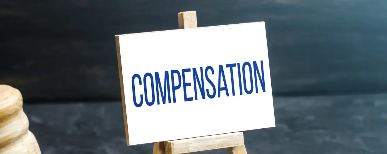 A small board with blue writing on saying compensation which might be appropriate under tenant rights for water damage