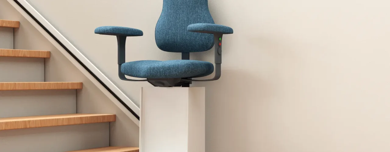 A stairlift with a blue chair, going up a wooden staircase