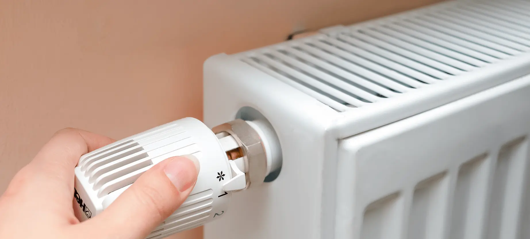 A person adjusting their radiator to heat their rental property