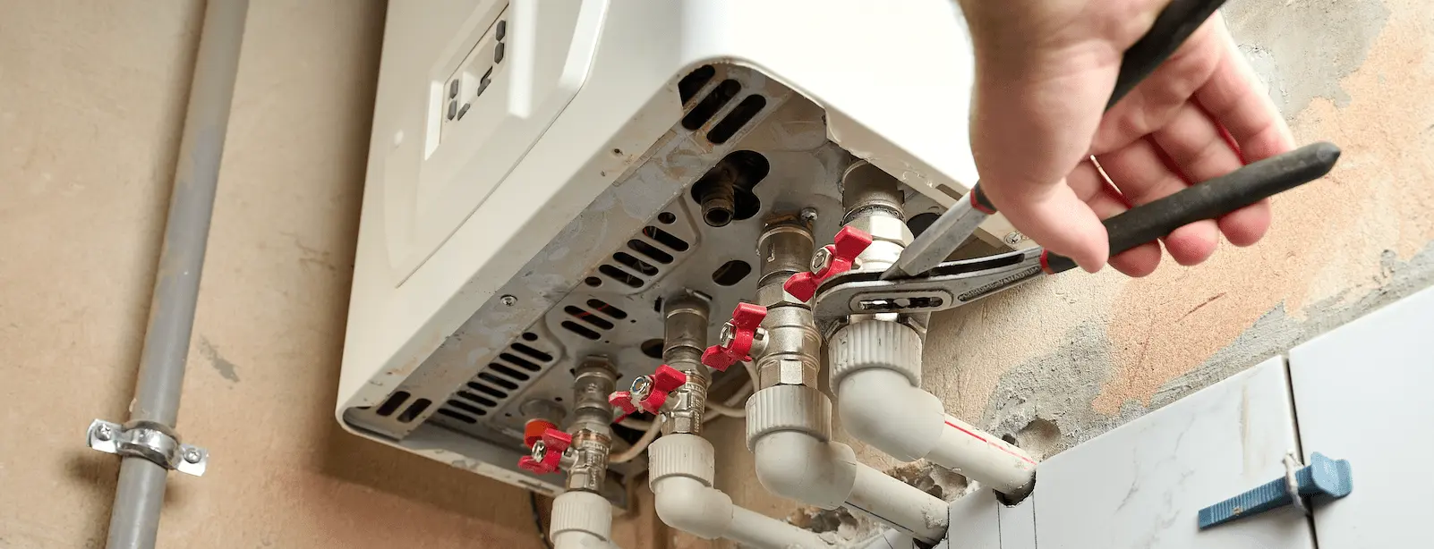Plumbing work being carried out on a boiler to heat a rental property