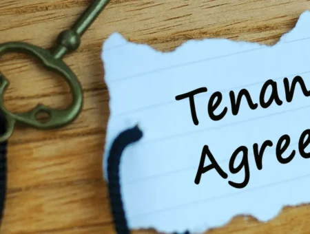 A key with a piece of paper attached. The paper says tenancy agreement