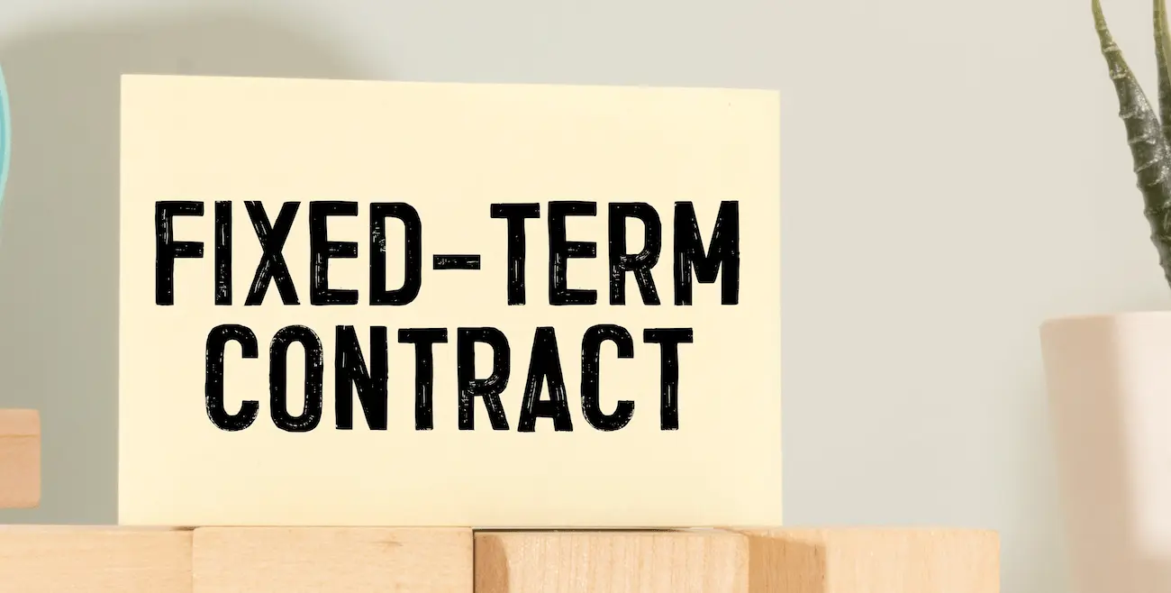 A wooden block with the words fixed-term contract on in black