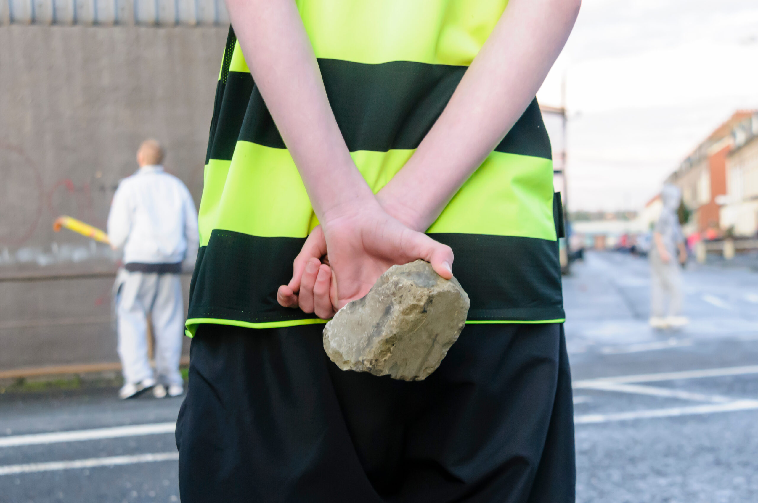 Male holding a rock behind his back