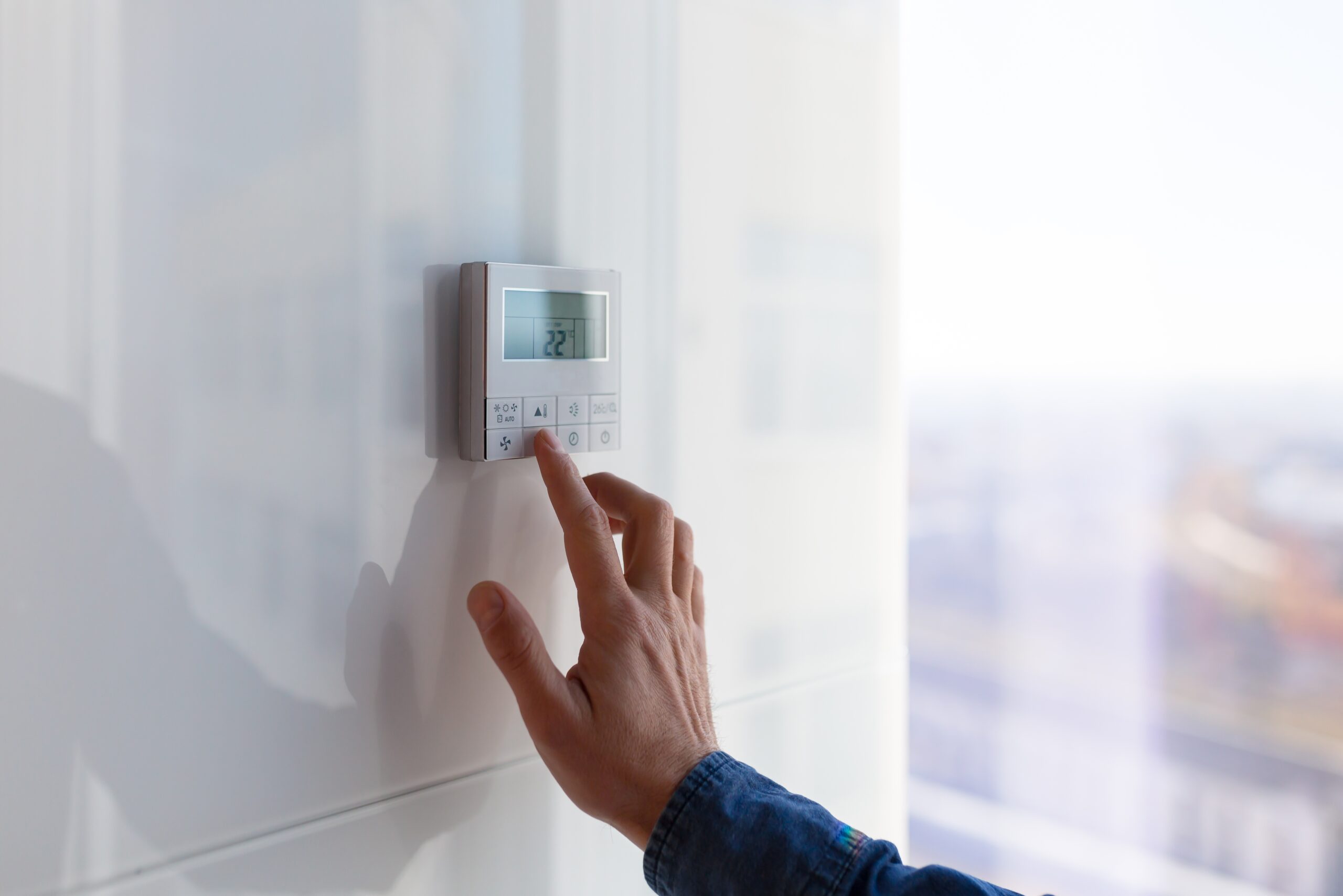 A tenant turning up the heat on a thermostat