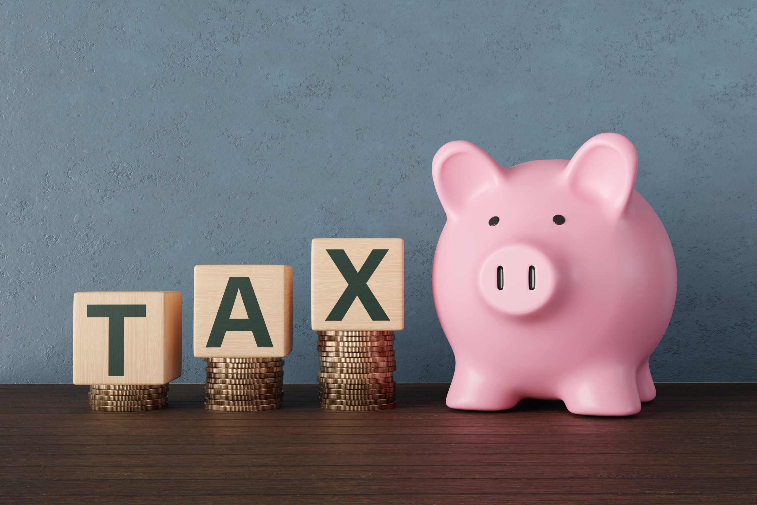 A piggy bank with 'tax' spelled out with word tiles 