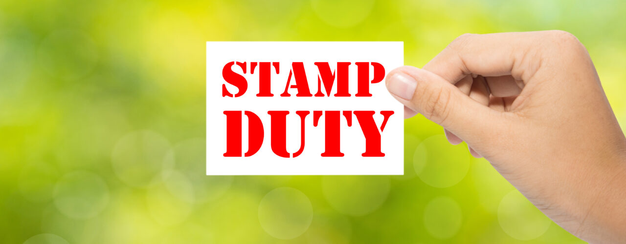 Someone holding a 'stamp duty' sign