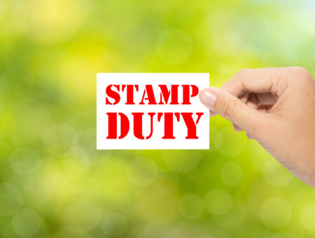 Someone holding a 'stamp duty' sign