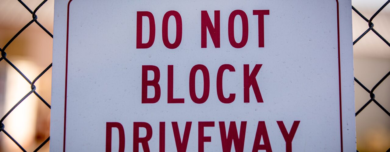 A sign that says 'Do not block driveway'