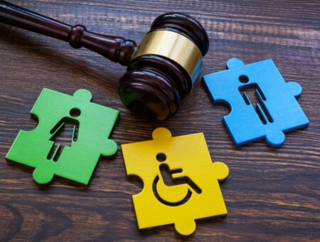 An image of a gavel and jigsaw pieces with outlines of people in a wheelchair