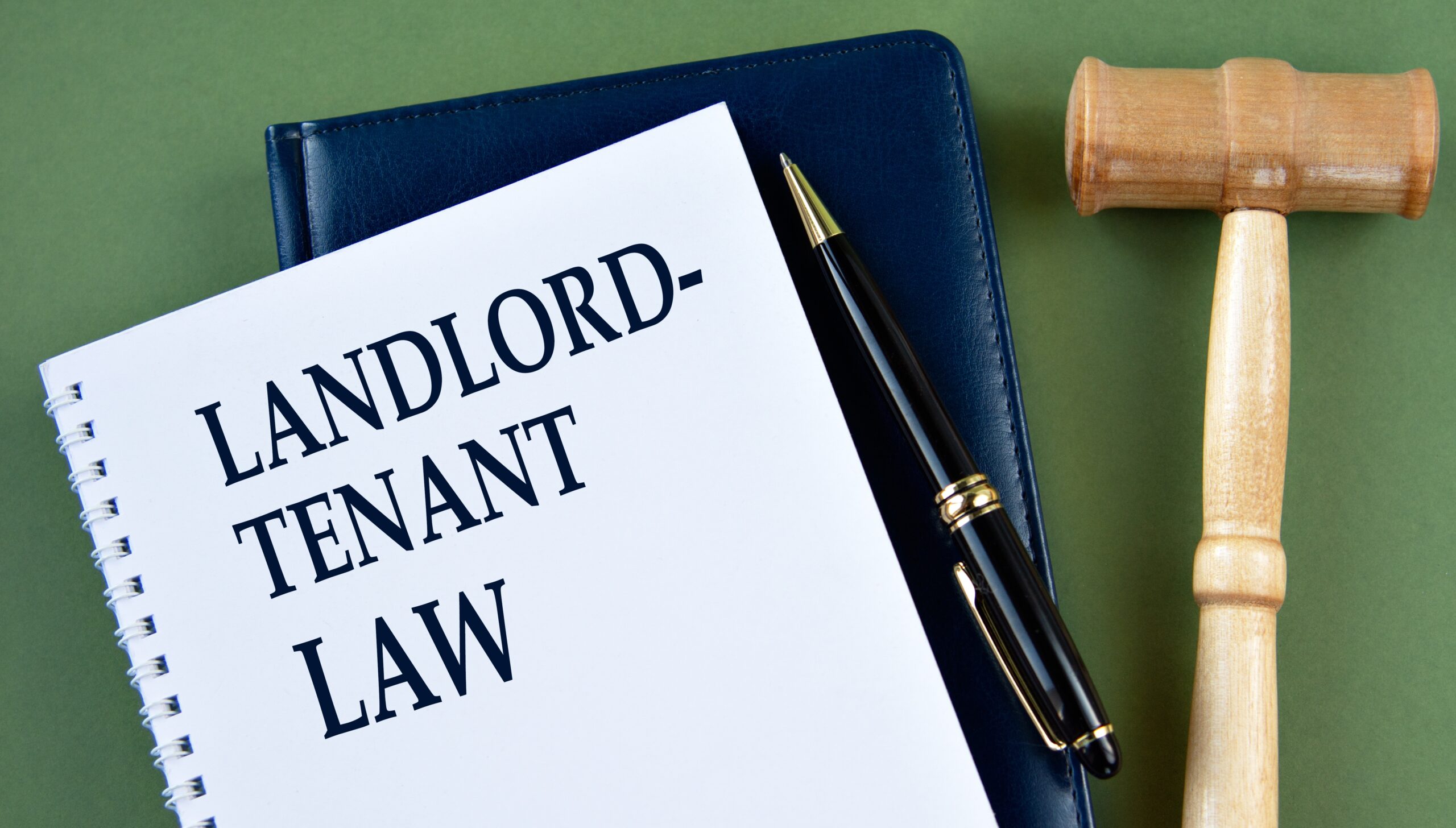 A gavel and a sign that says 'landlord-tenant law'