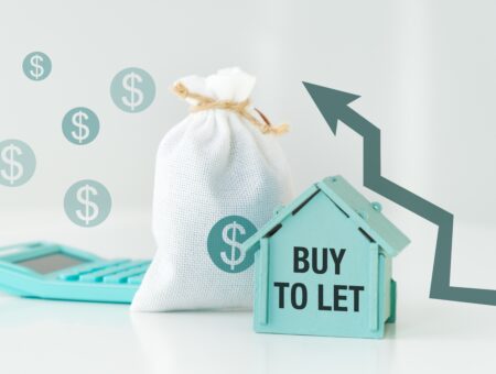 A model house with a sack of money behind it to illustrate finances associated with buy-to-lets