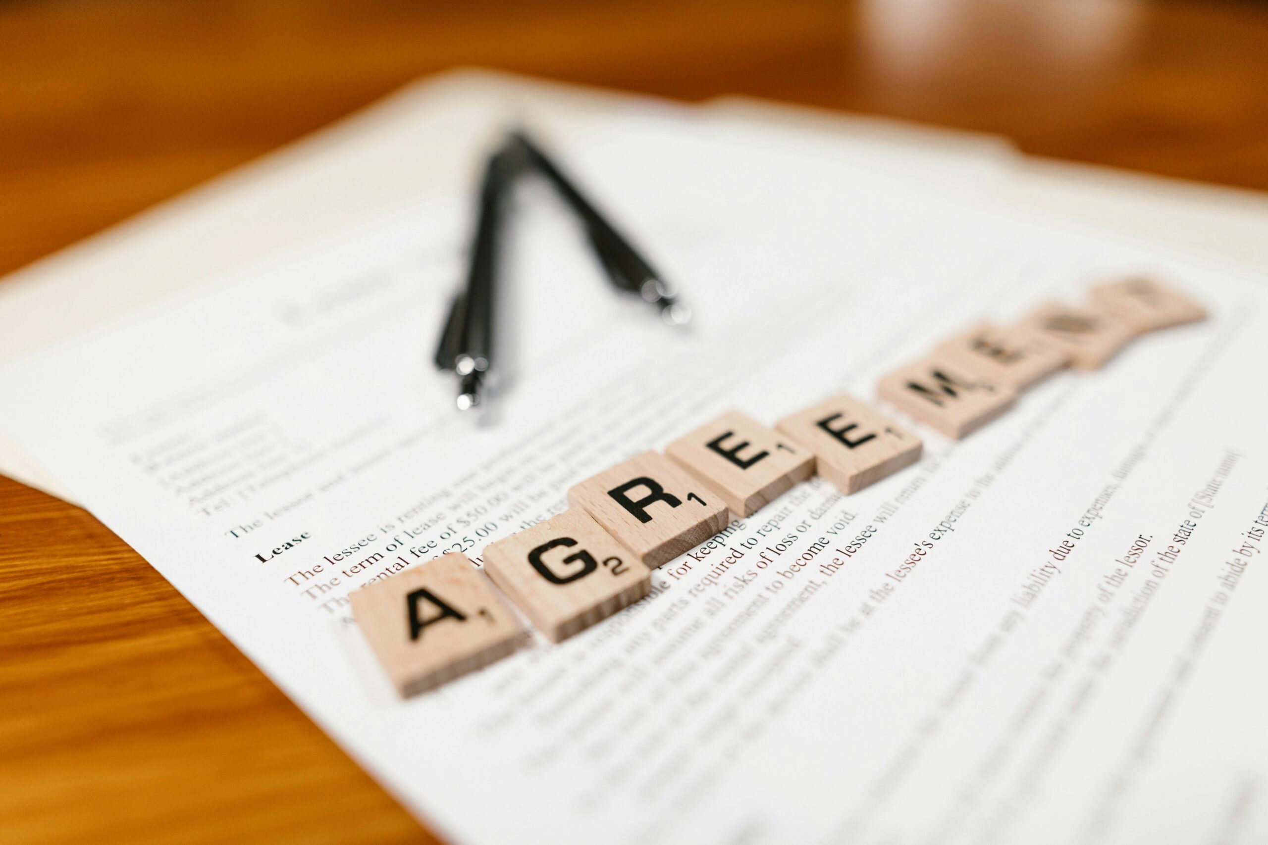 A lease agreement with scrabble letters that spell 'agreement'