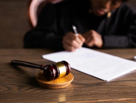 An image of a gavel and someone signing a legal document