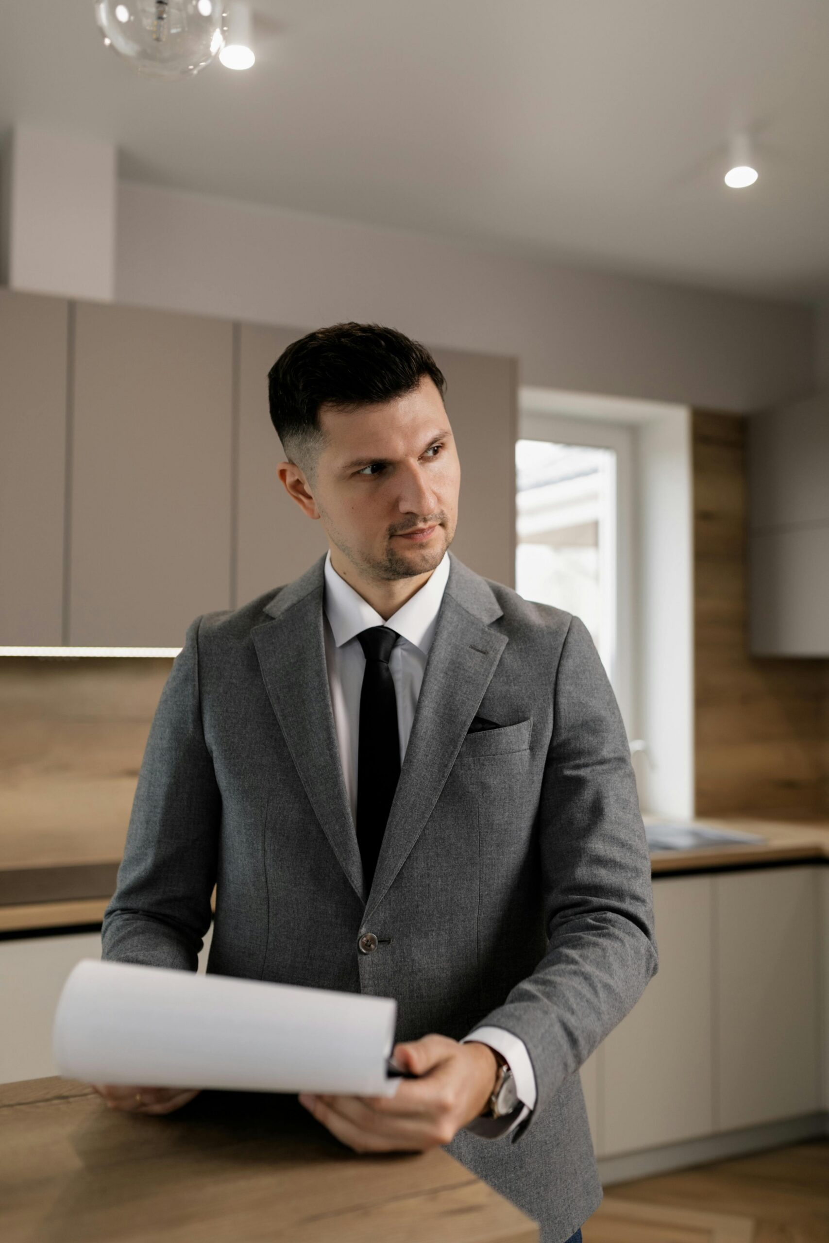 A man dressed in a suit with a piece of paper in his hands.