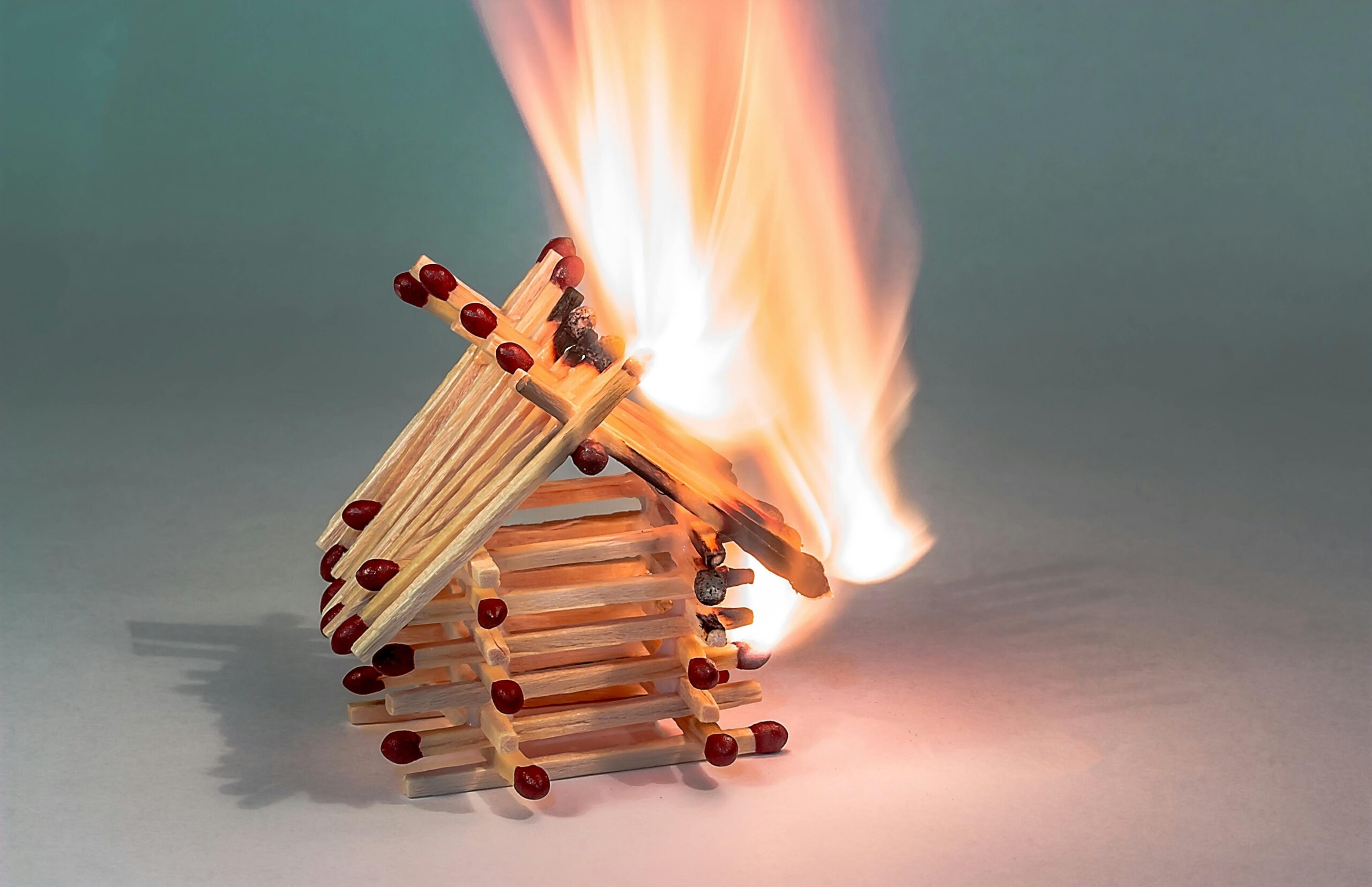 A house built out of matches that are alight