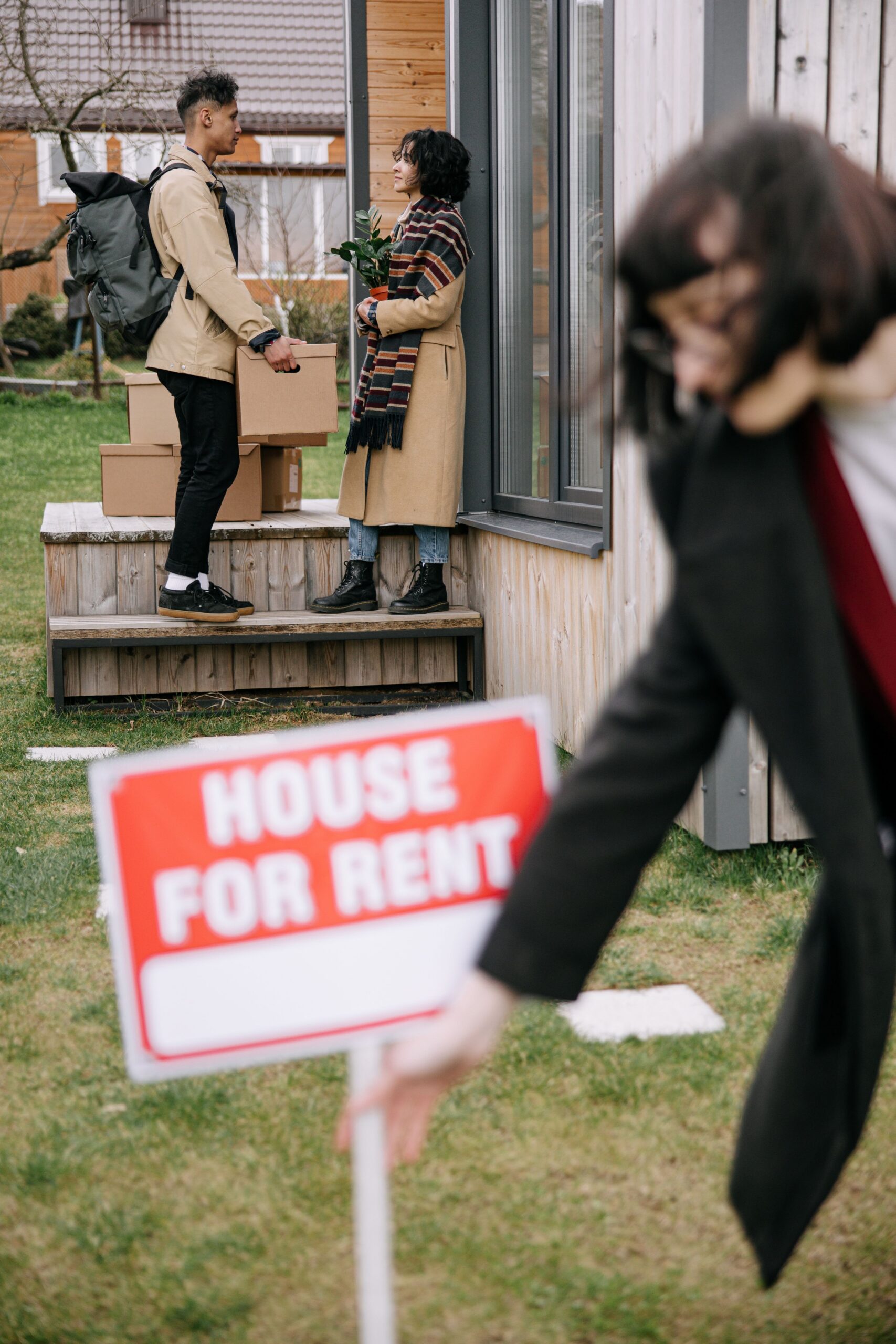 A woman taking out a 'house for rent' sign